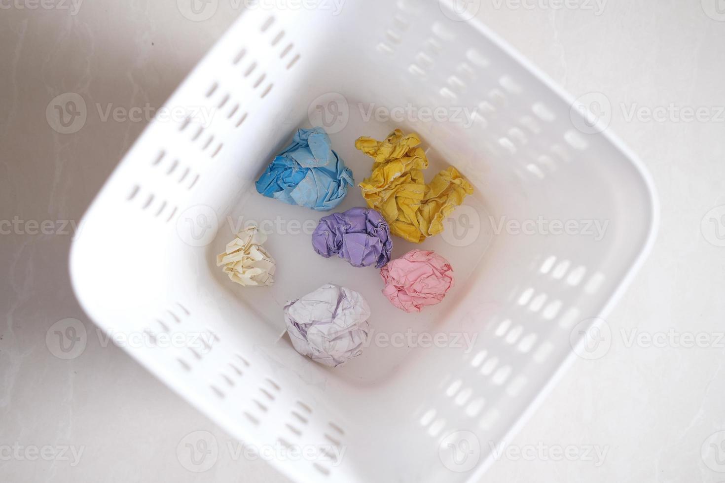 Crumpled paper balls in a bin top view photo