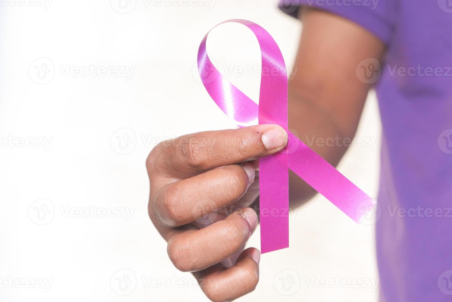 Hand holding pink ribbon close up photo