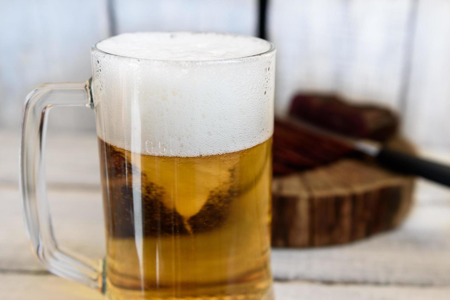 cerveza y pastrami en la mesa de madera foto