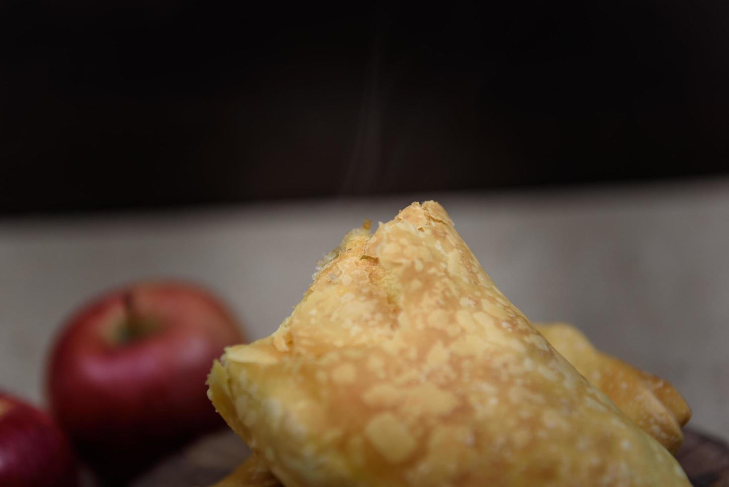 Apple strudel on wooden end of a tree with apples, cinnamon and star anise photo