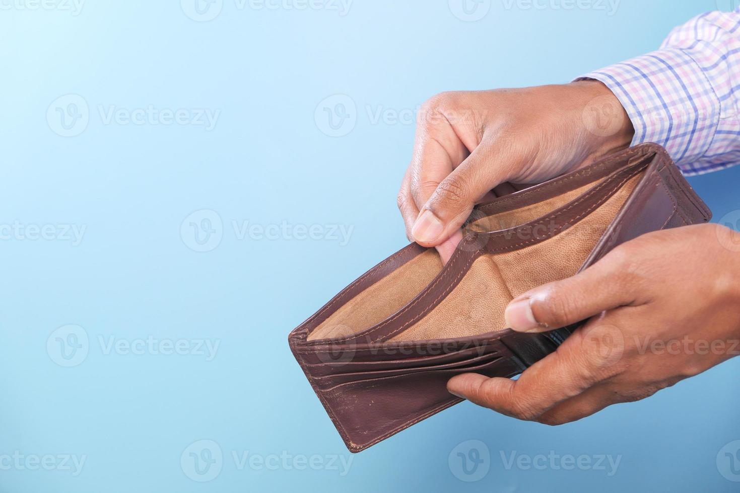 Hand holding empty wallet with blue copy space photo