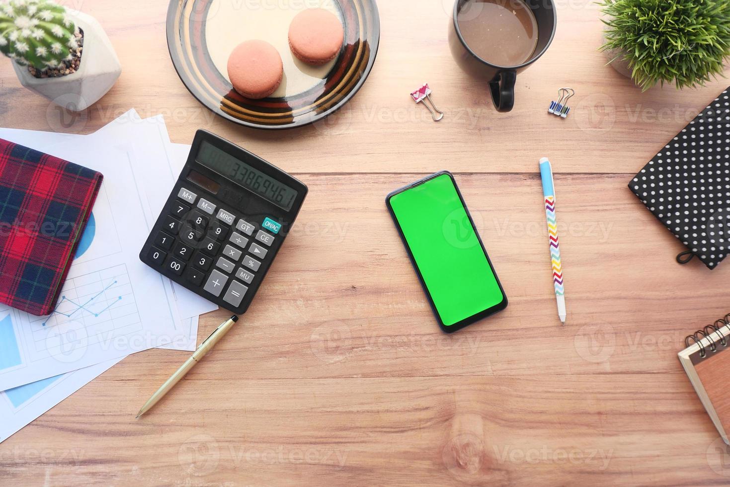 Vista superior del teléfono inteligente en un escritorio con desayuno y calculadora foto