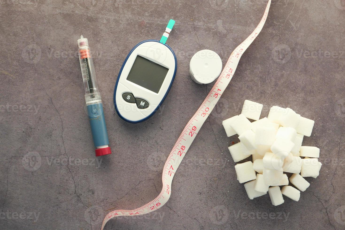 Diabetic measurement tools, insulin. and sugar cubes photo