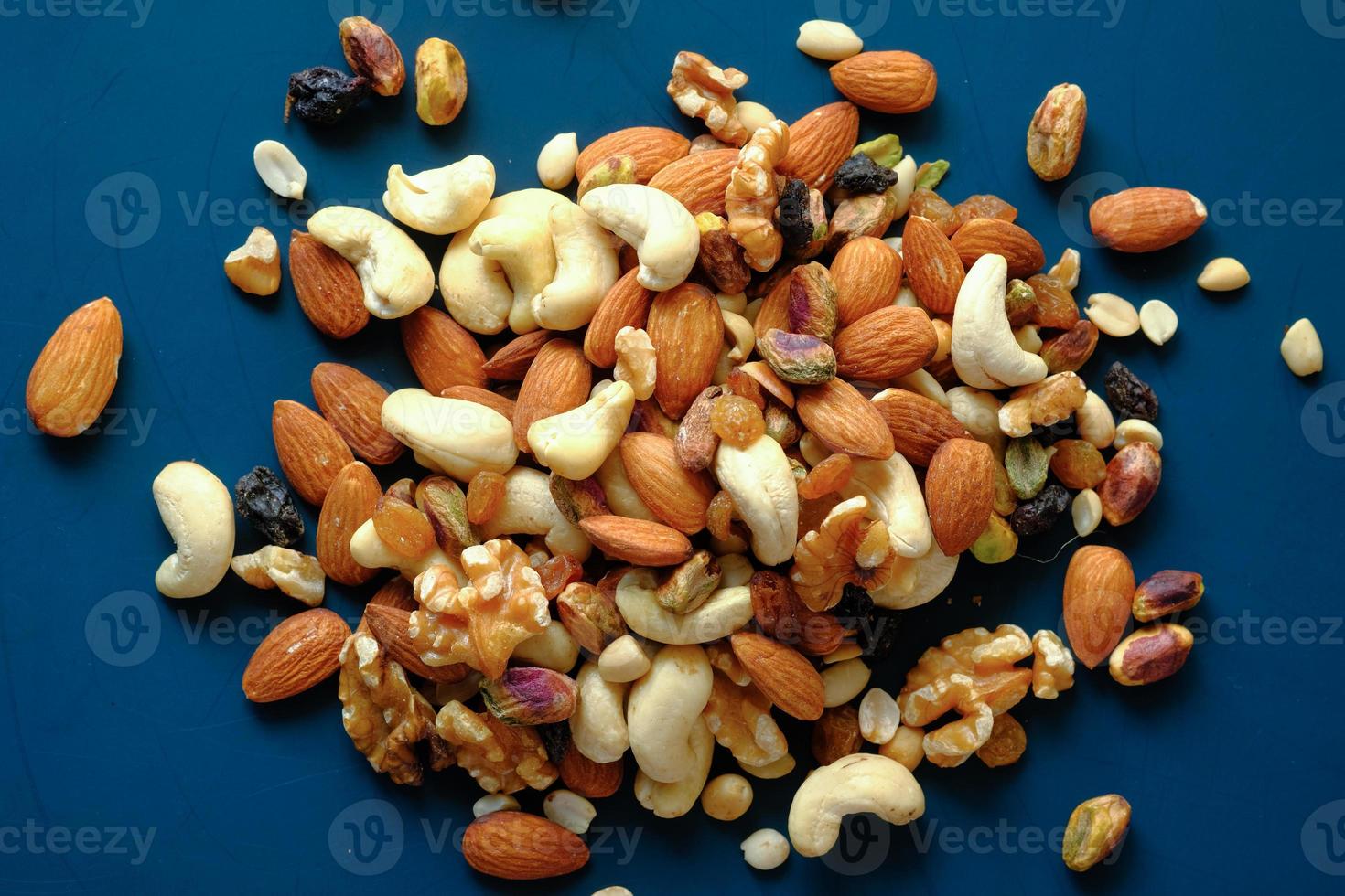 Many mixed nuts on blue background photo