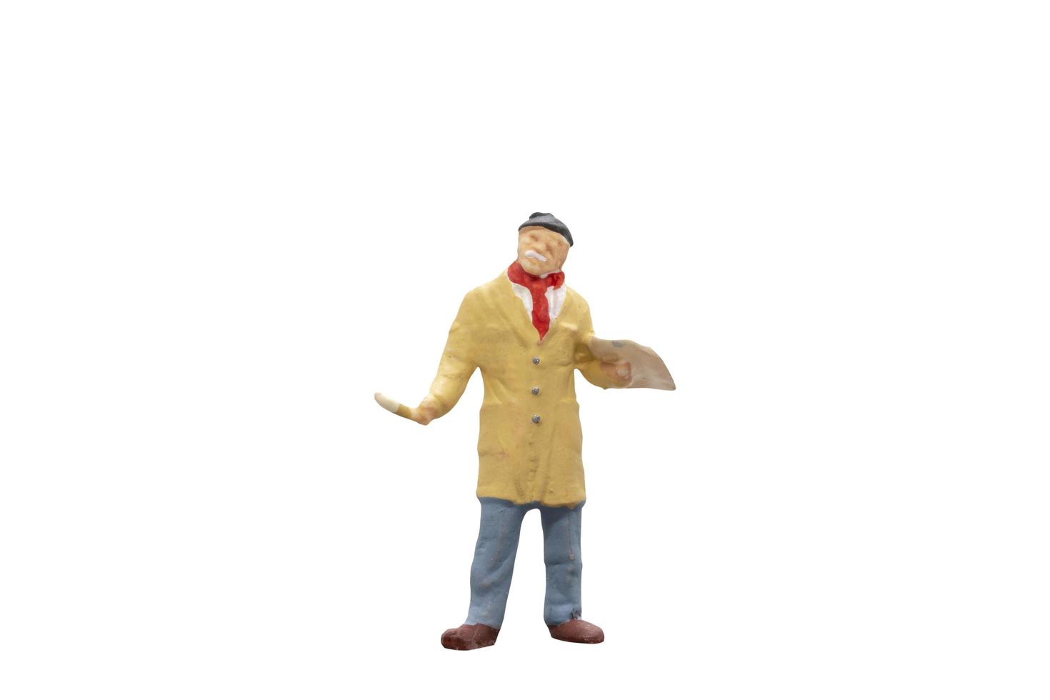 Miniature artist holding a brush and color paint palette on a white background photo