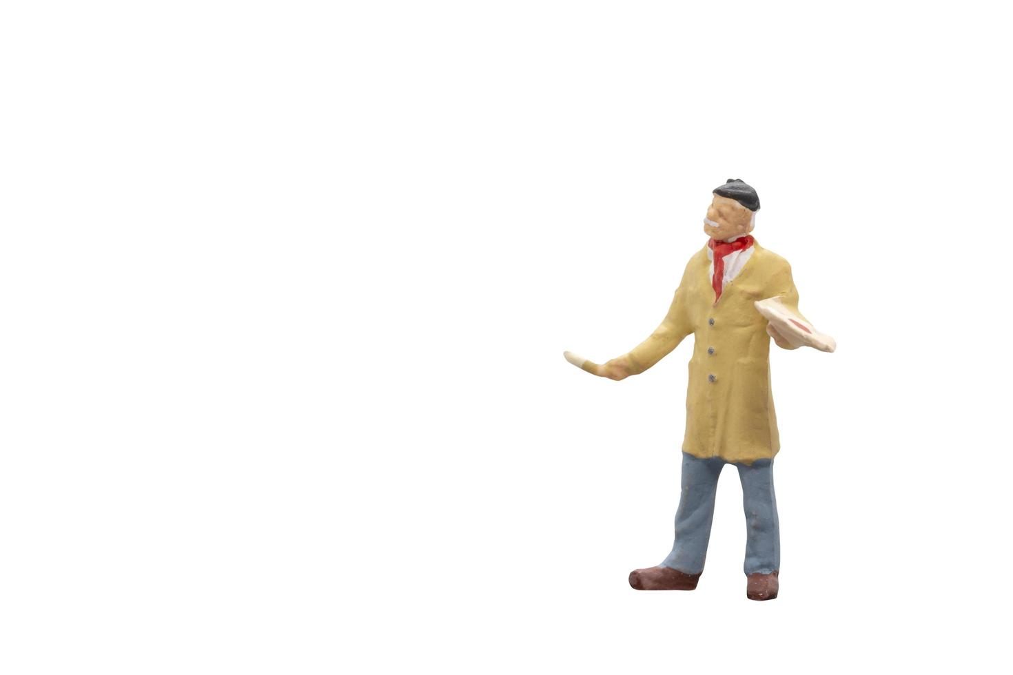 Miniature artist holding a brush and color paint palette on a white background photo