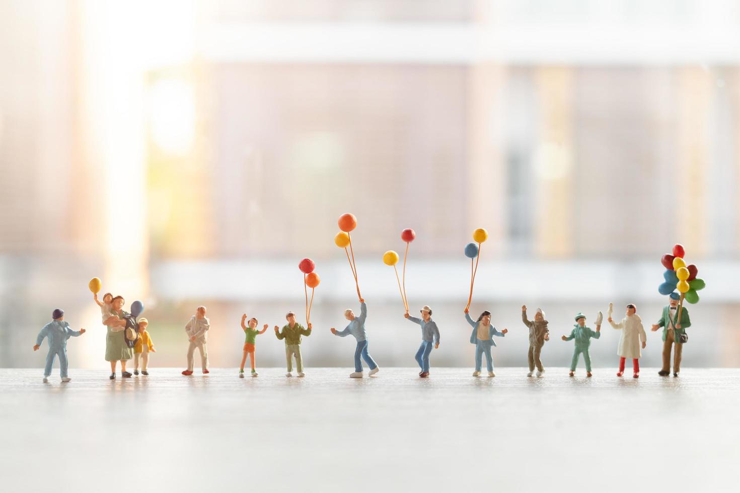 Gente en miniatura caminando con globos, concepto de familia feliz foto