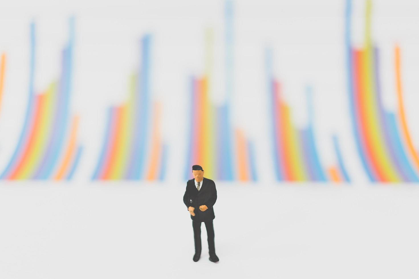 Miniature businessmen standing on a chart background photo