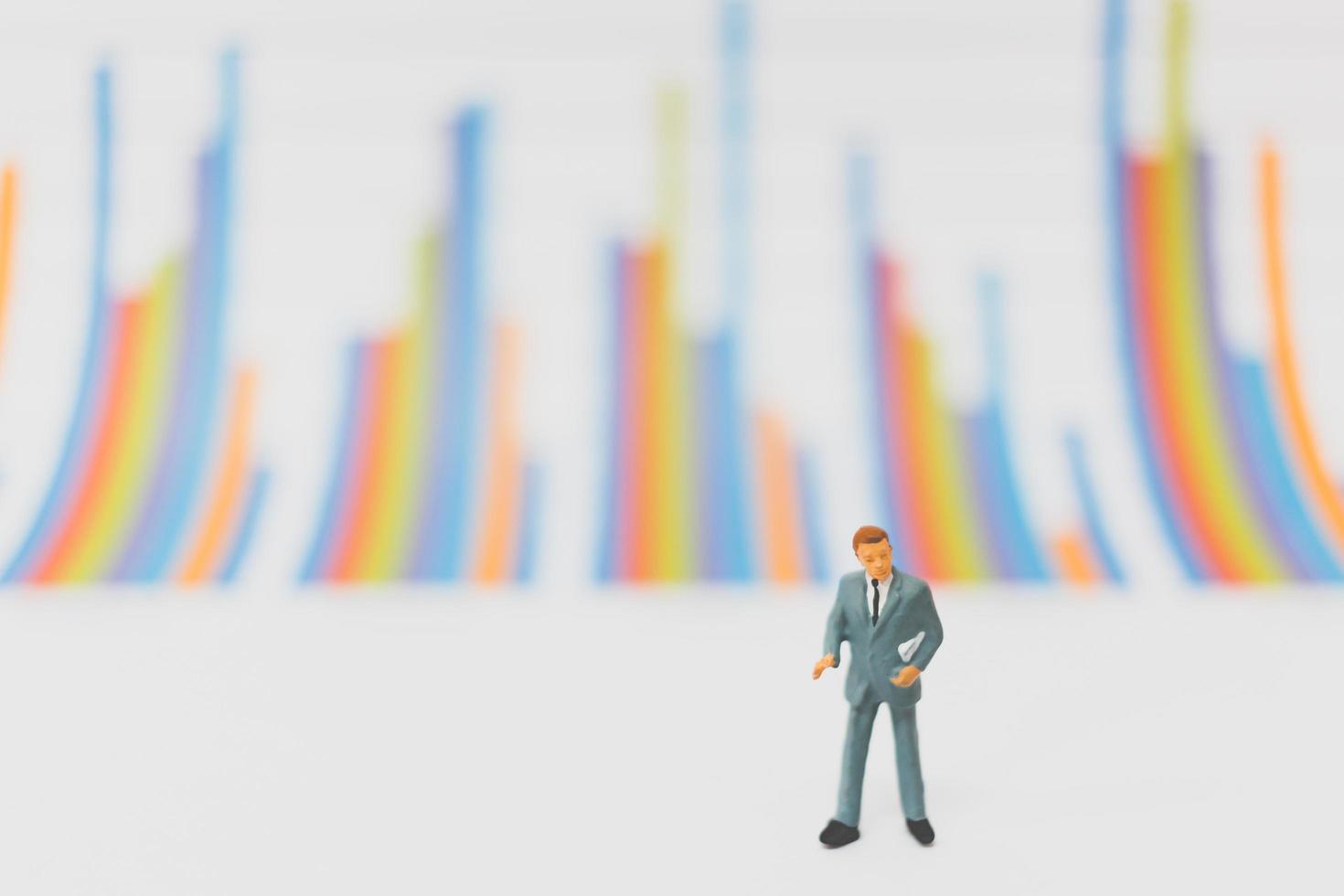 Miniature businessmen standing on a chart background photo