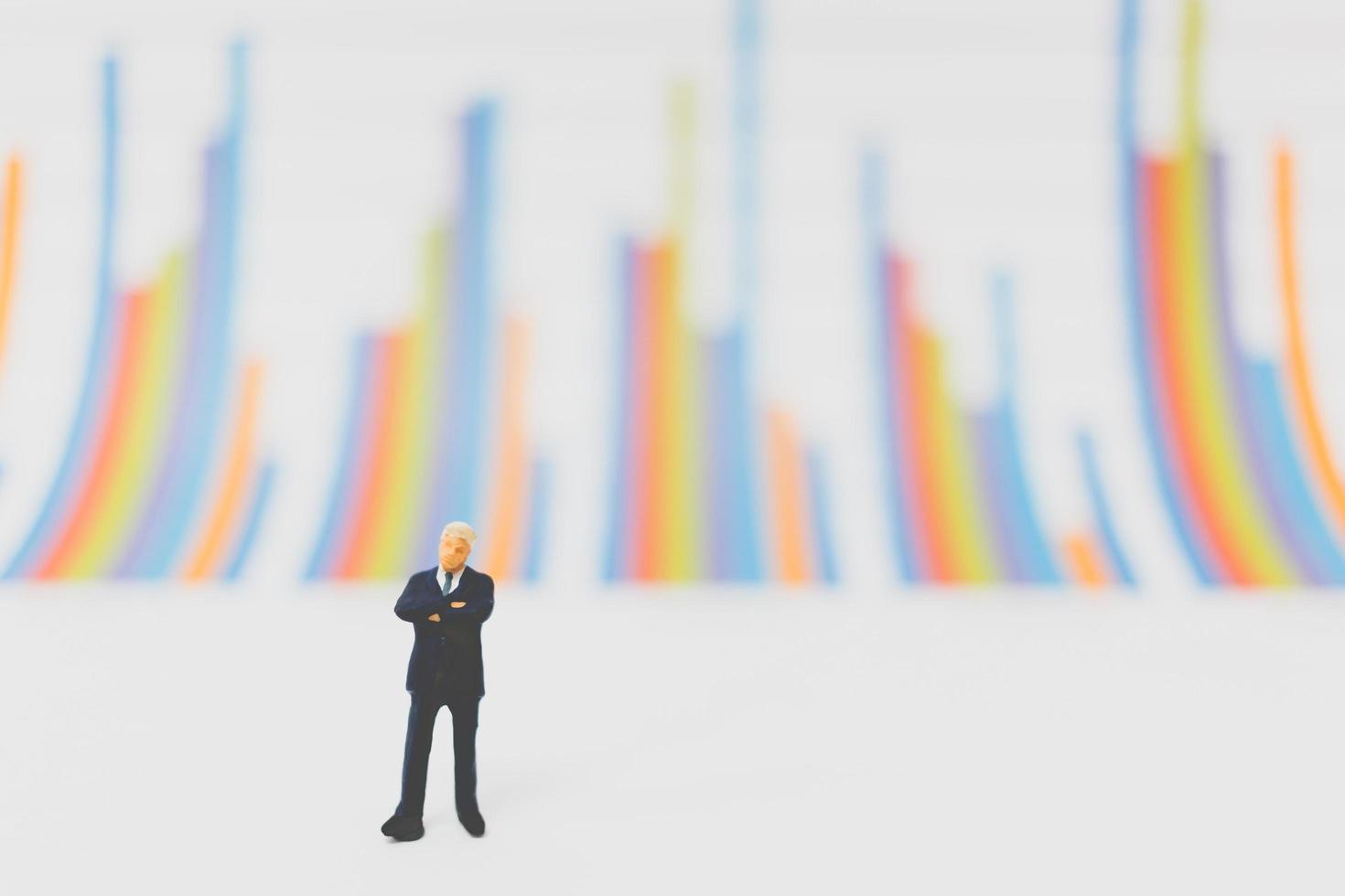 Miniature businessmen standing on a chart background photo