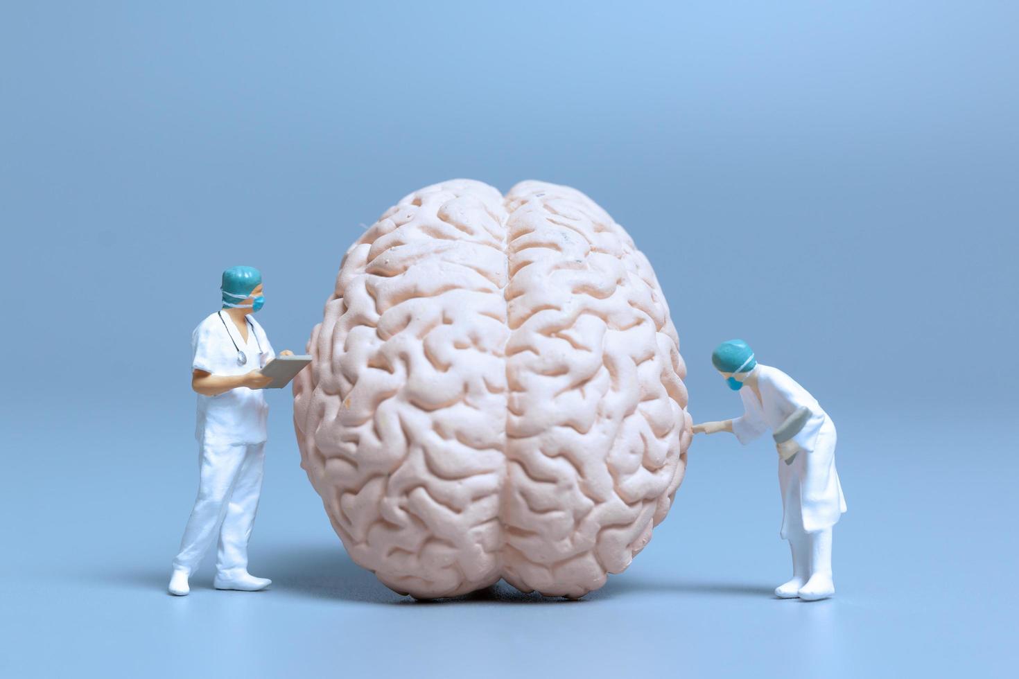 Miniature doctors checking and analyzing a brain for signs of Alzheimer's disease and dementia, science and medicine concept photo