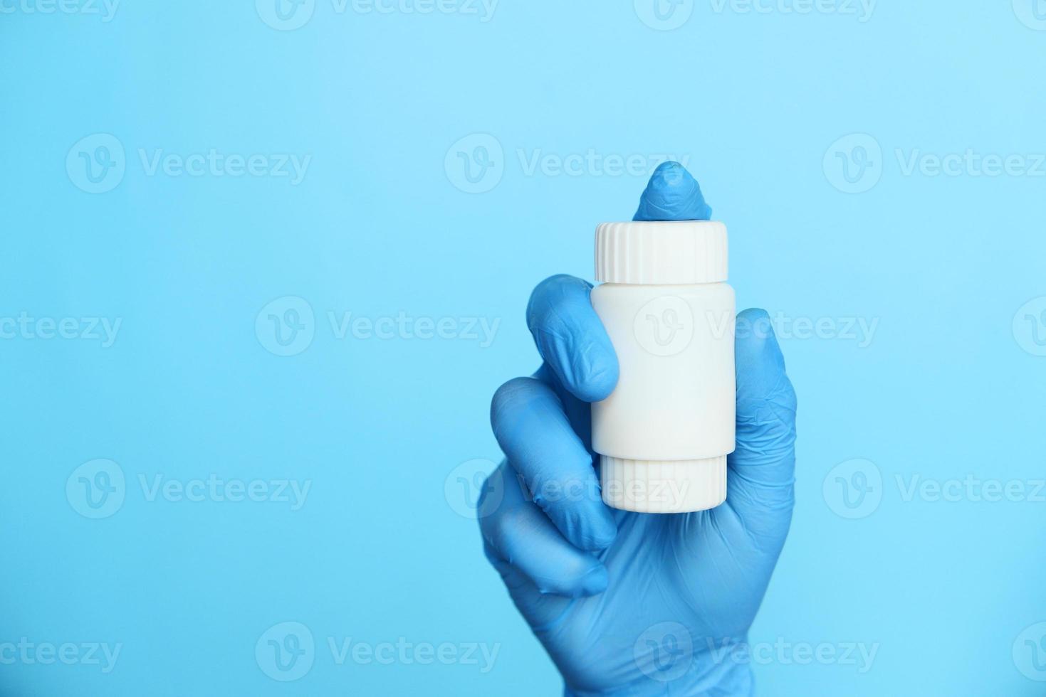 Contenedor de pastillas en blanco sobre fondo azul. foto