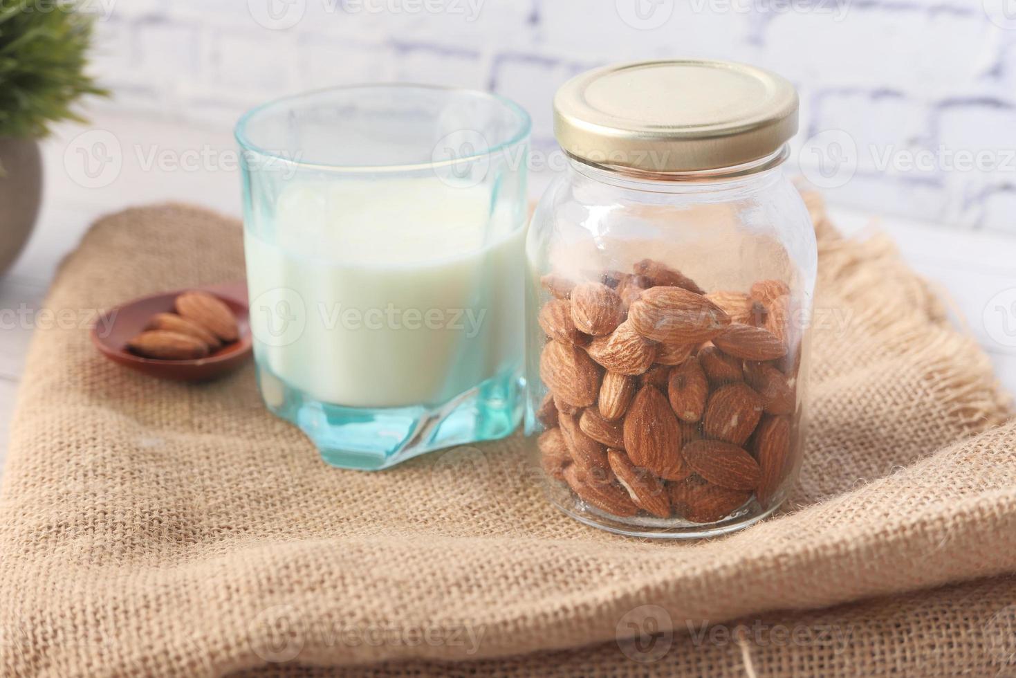 Almonds and plant milk on neutral background photo