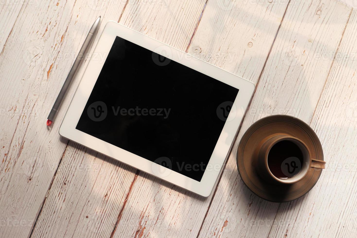 Flat composition of digital tablet and tea on wooden background photo