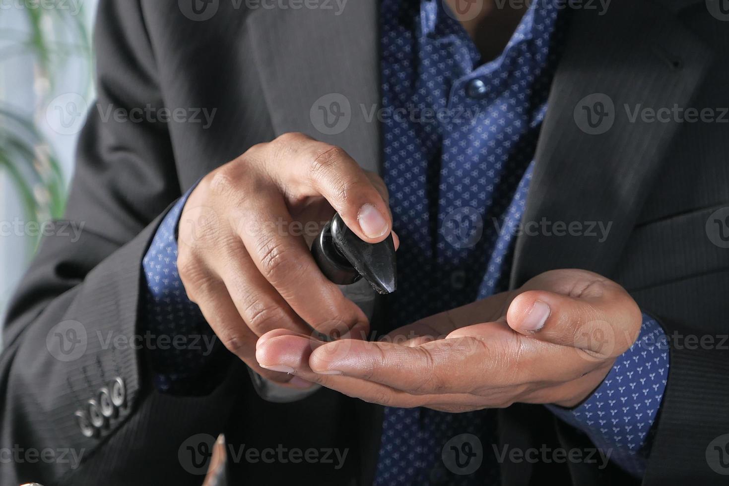 Businessman using sanitizer gel photo