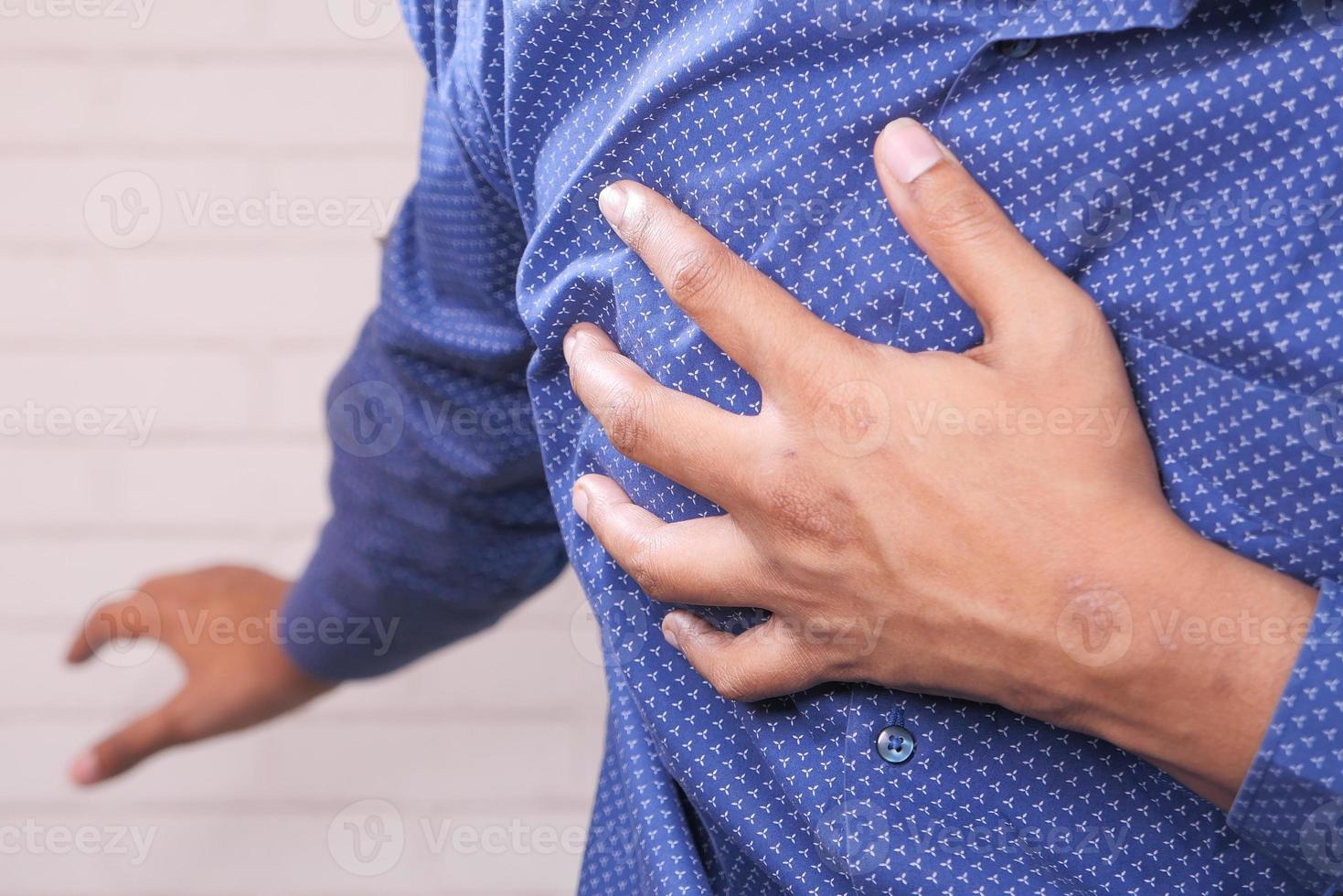 Young man holding chest in pain photo