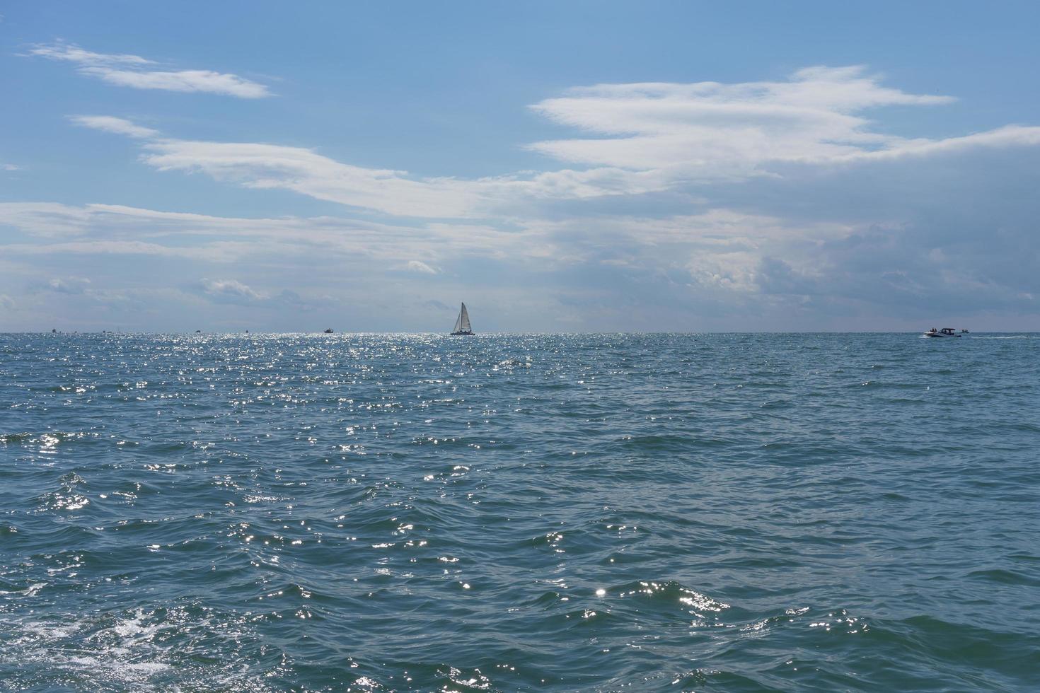 Seascape con barcos distantes en un cuerpo de agua contra el nublado cielo azul en Sochi, Rusia foto