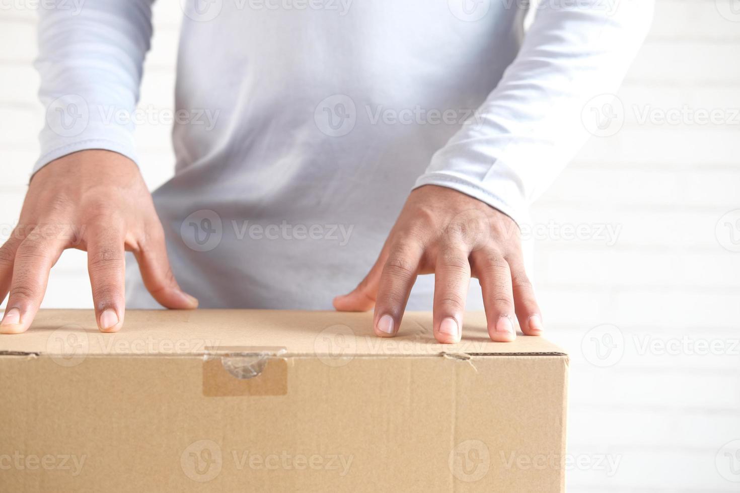 Man's hand opening a cardboard box photo