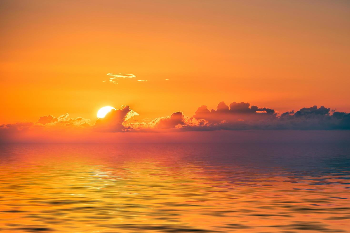 Orange cloudy sunset over body of water photo