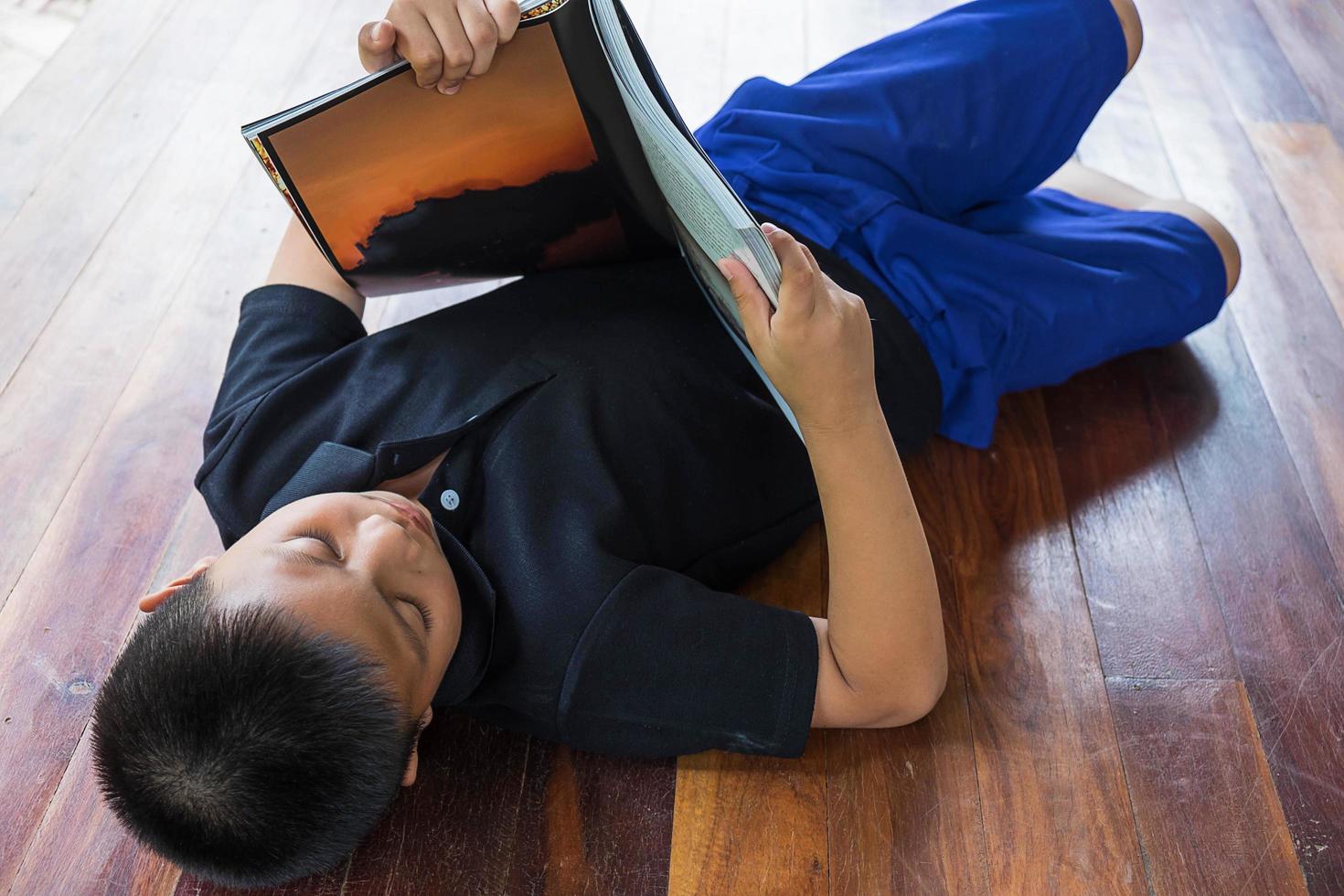 Boy laying down while reading photo