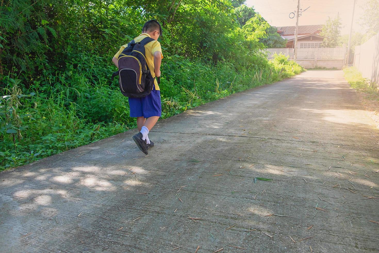 Boy walking outside while wearing a backpack photo