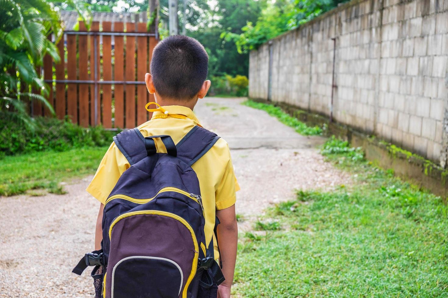 niño con una camisa amarilla con una mochila foto