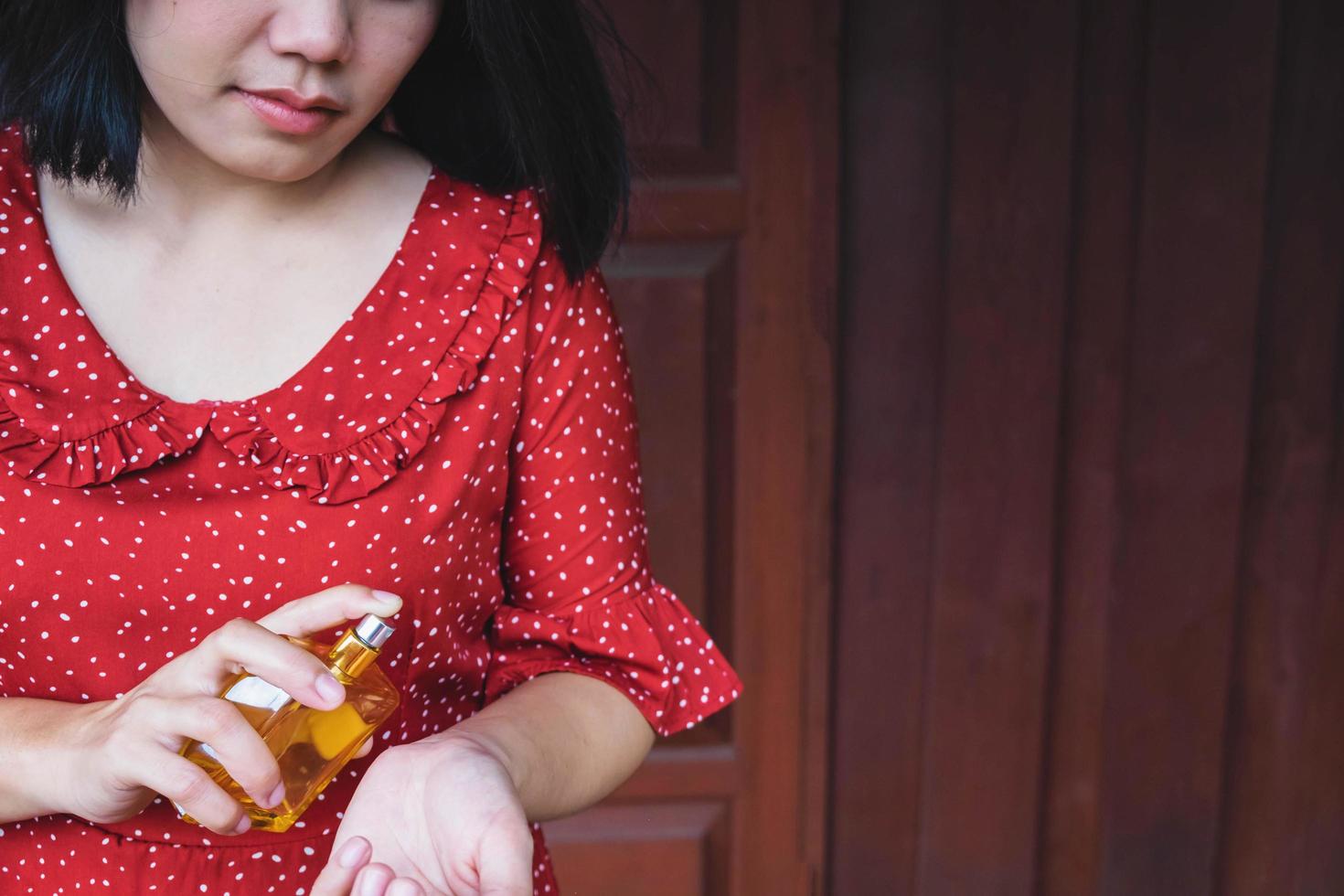 Woman spraying perfume on her wrist photo