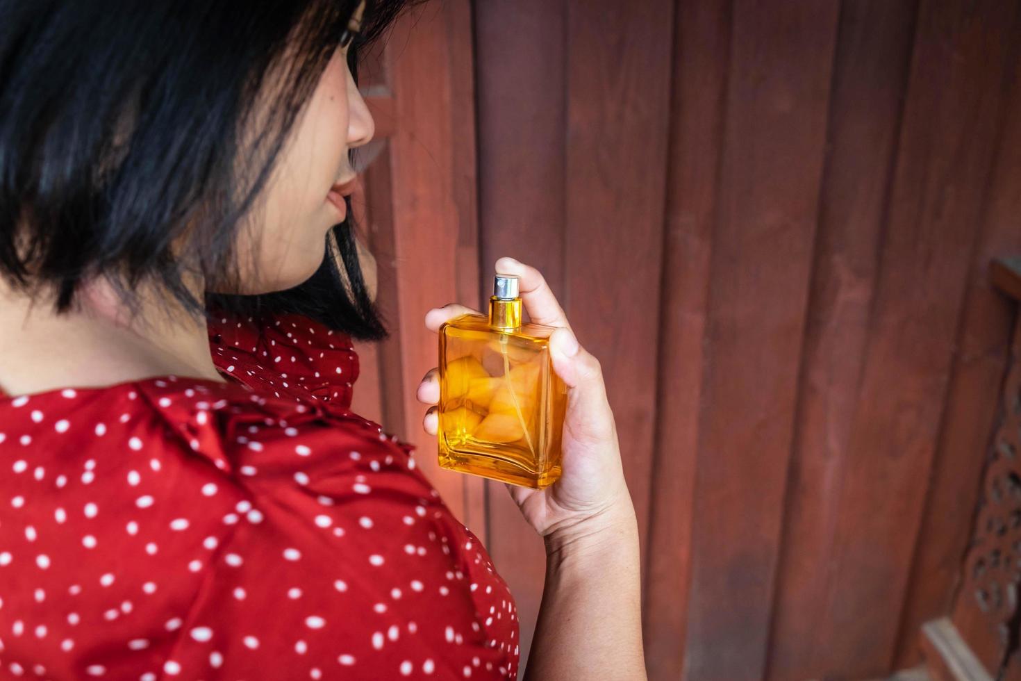 mujer, rociar, frasco de perfume foto