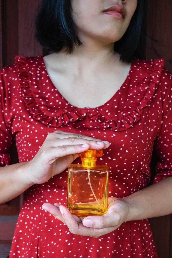 mujer sosteniendo una botella de perfume foto