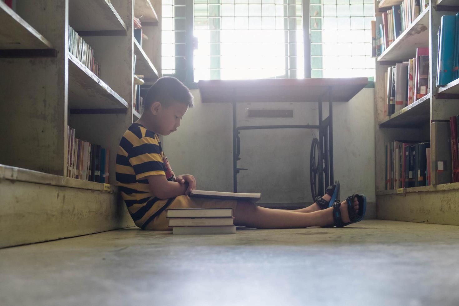 Boy reading in a library photo