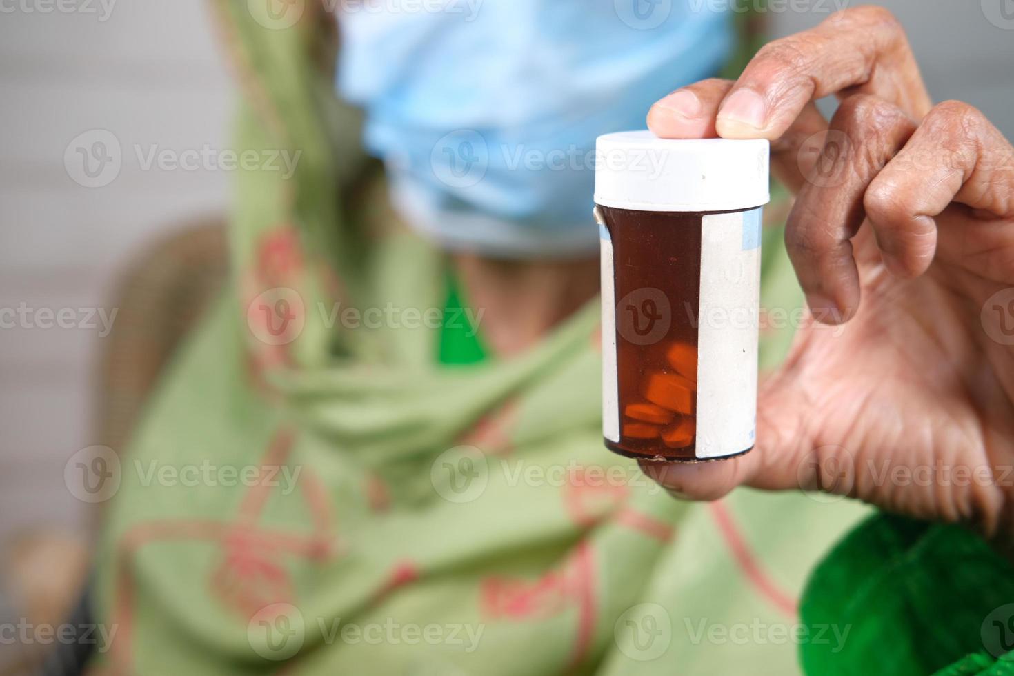 anciana sosteniendo una botella de pastillas foto