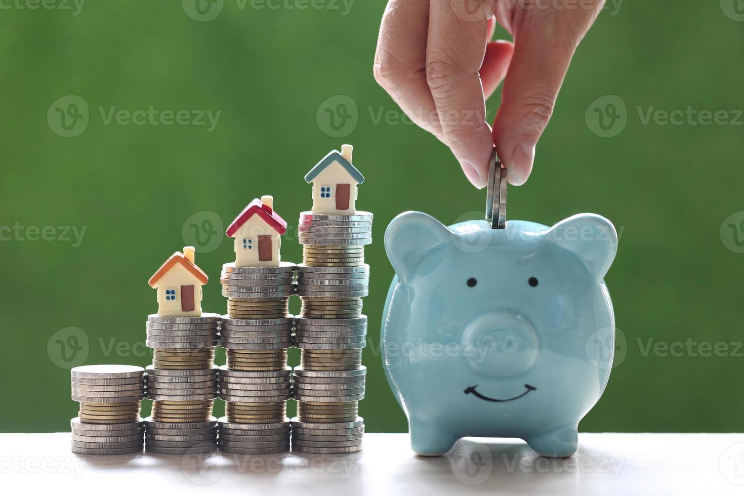 Model house on stacks of coins on a natural green background, business investment and real estate concept photo