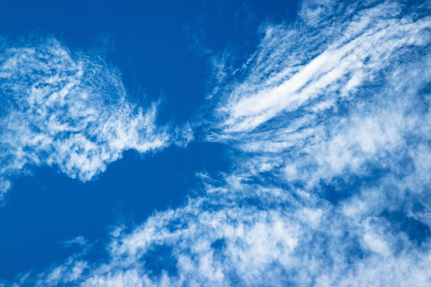 Blue sky with swirling clouds photo