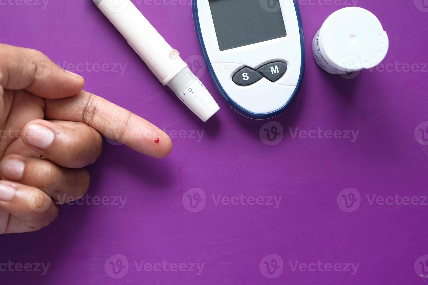 La mano del joven midiendo el nivel de glucosa en casa foto