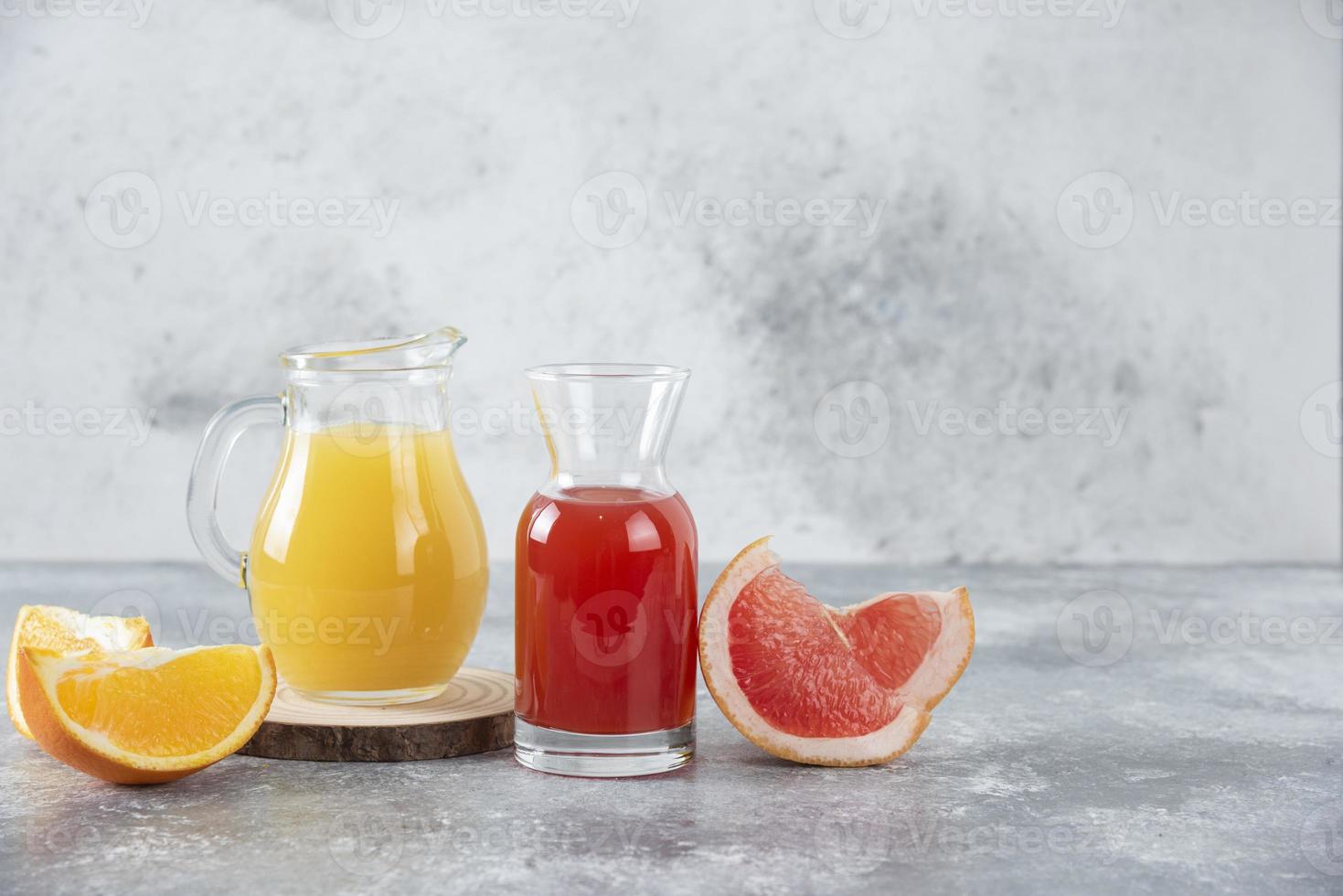 Two glasses of grapefruit and orange juice on A stone background photo