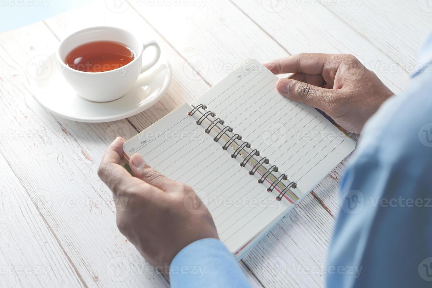 Man's hand turning the page of a notepad photo