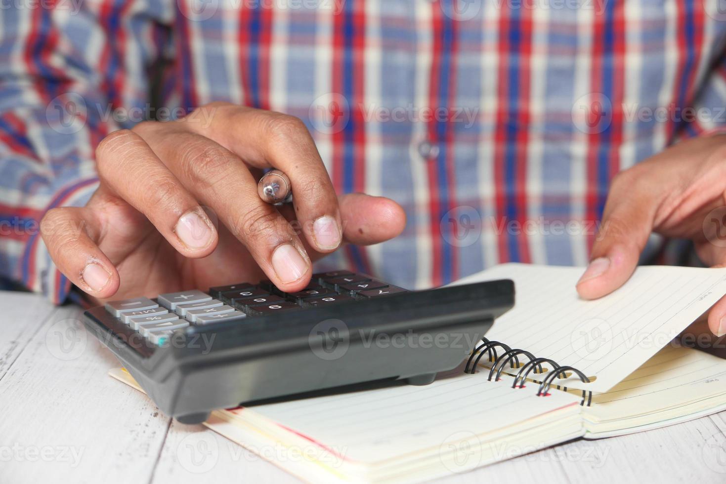 Close up of man's hand using calculator photo