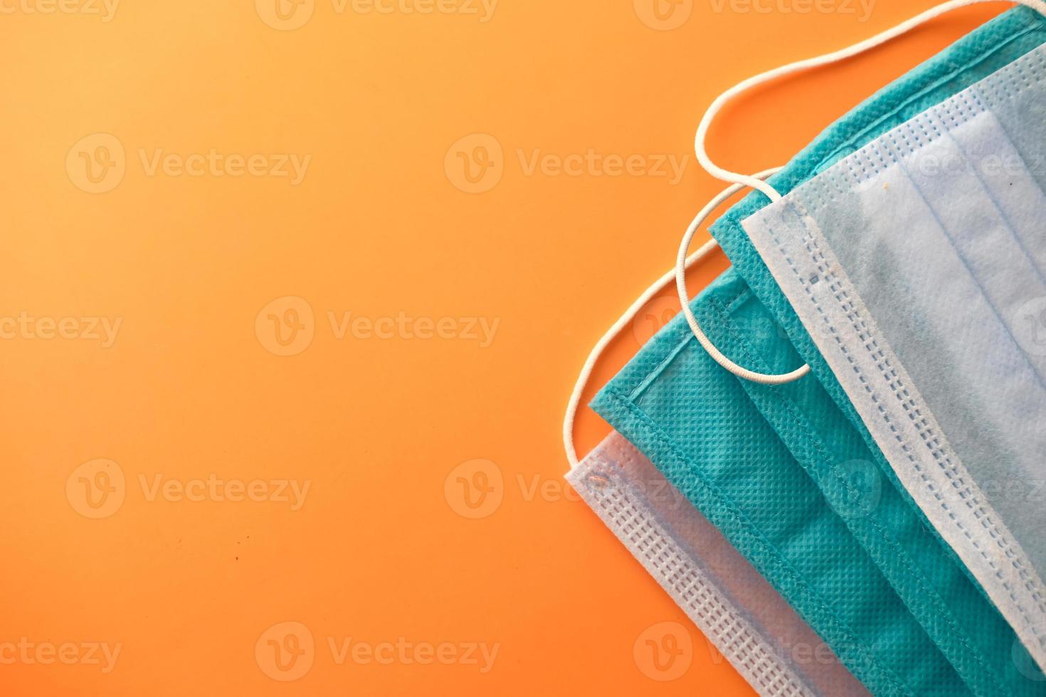 Close up of blue surgical masks on orange background photo