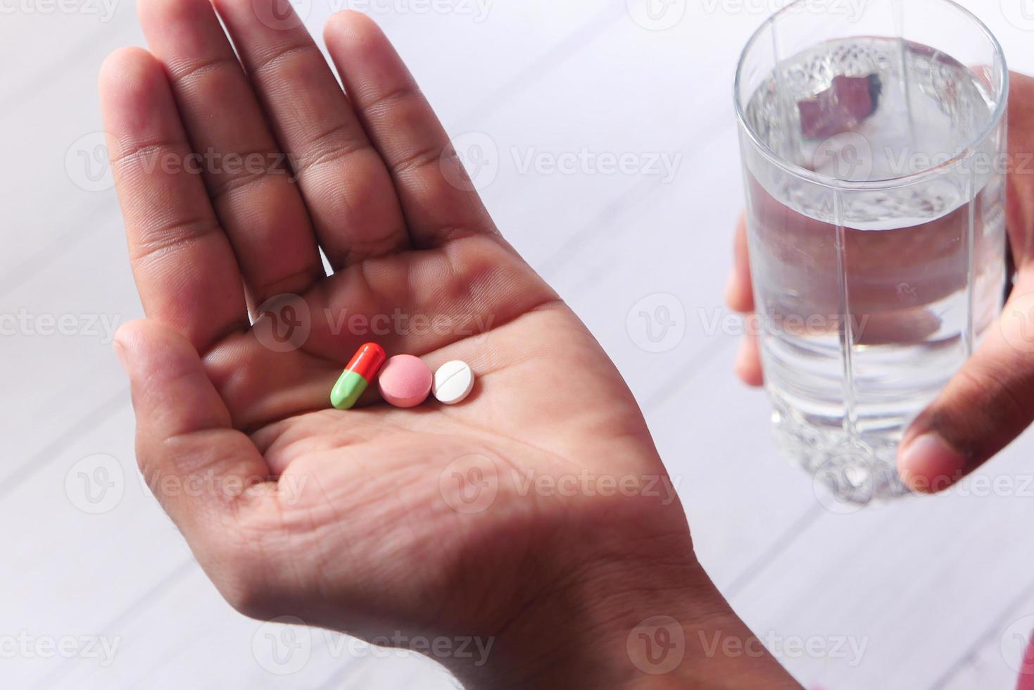 Cerca de la mano del hombre tomando medicina foto