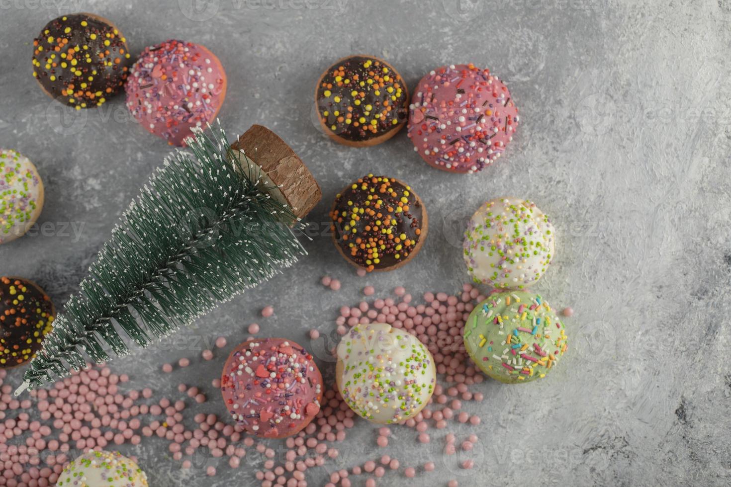 Colorful sweet small doughnuts with sprinkles and a Christmas ornament photo