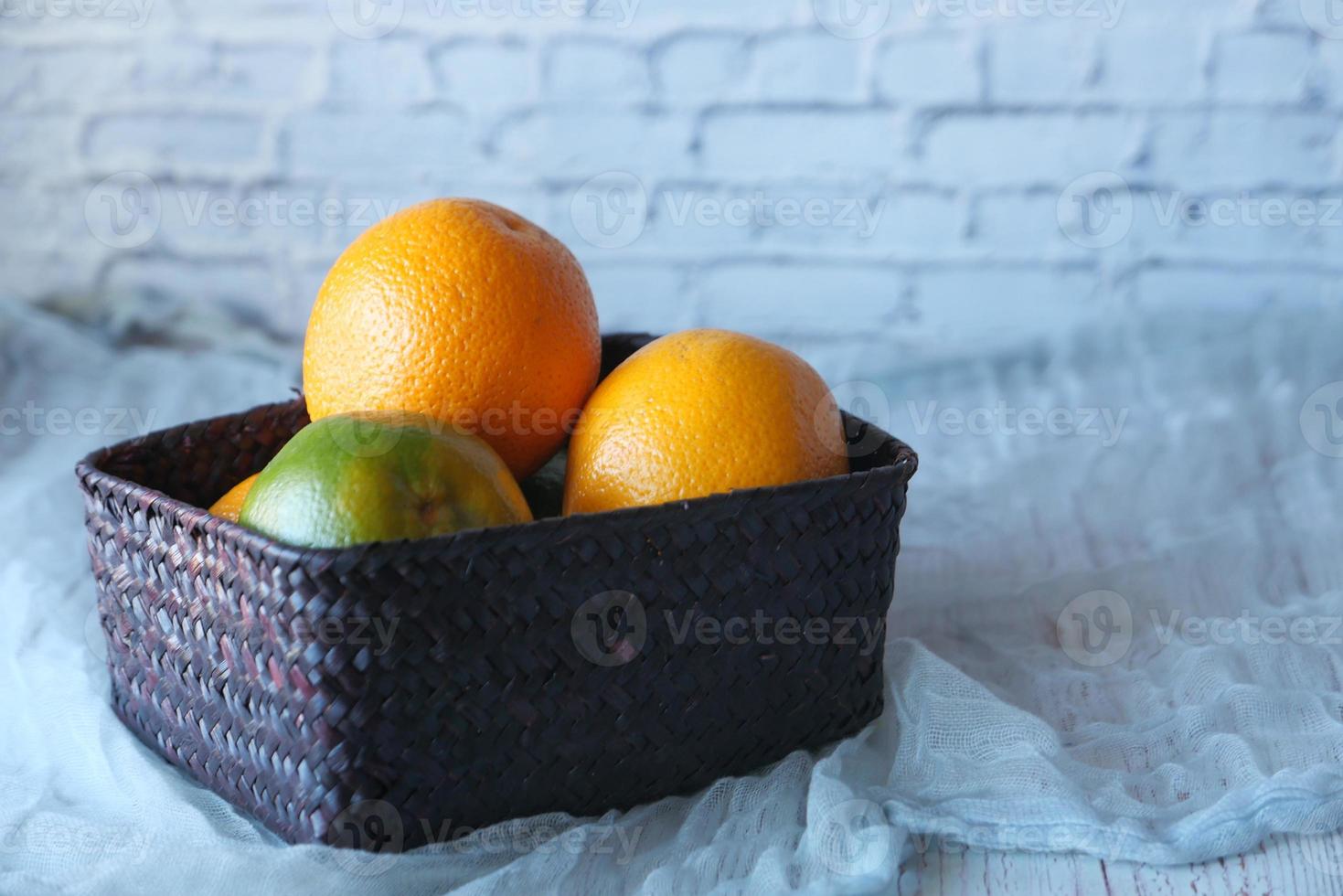 Orange fruit in a bowl on neutral background photo