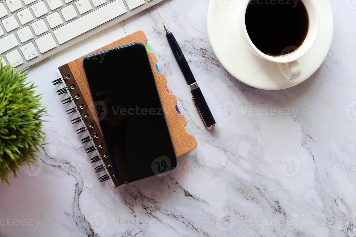 Top view of smart phone and notepad on table photo