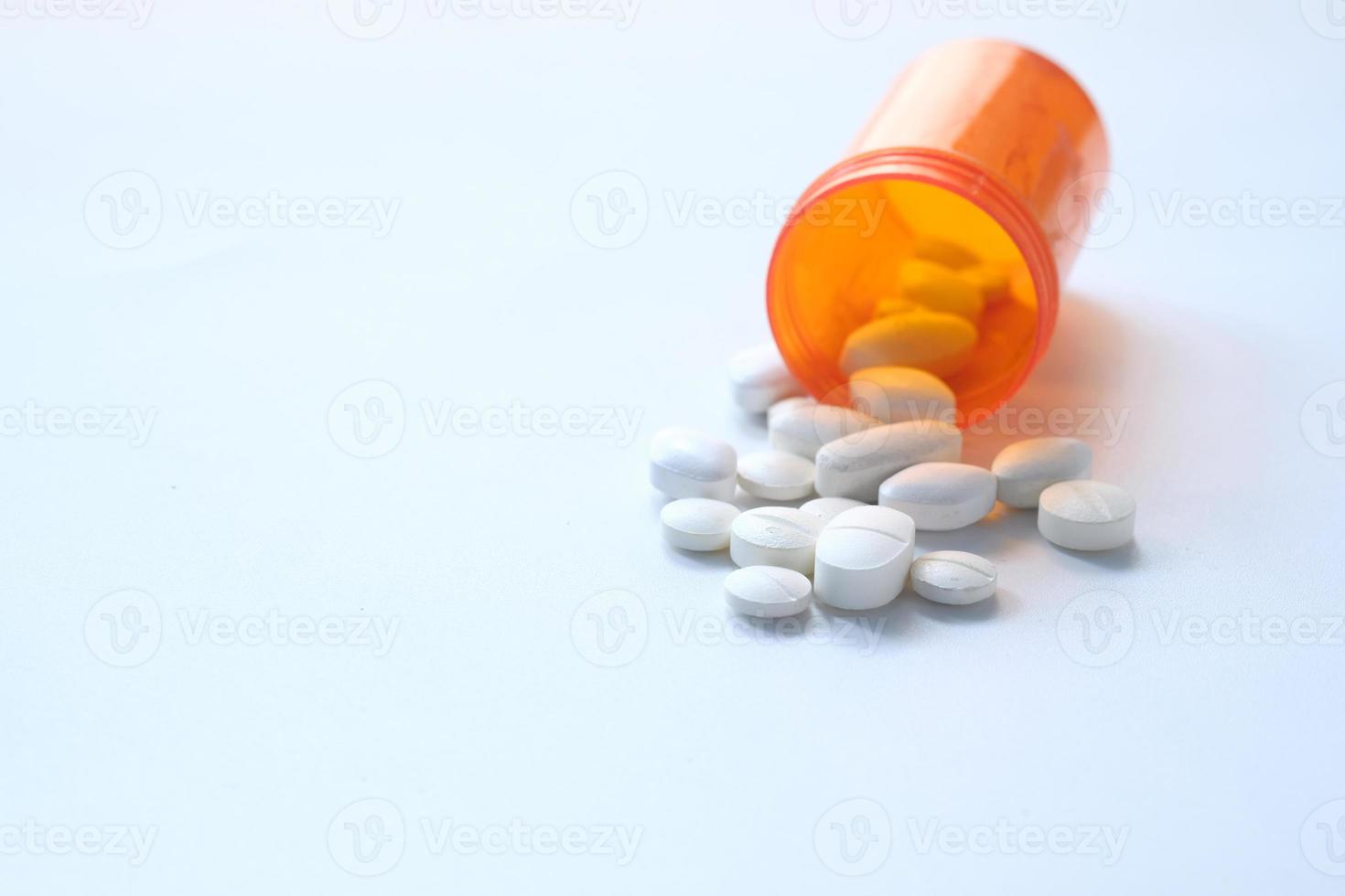 Close up of white pills spilling on white background photo