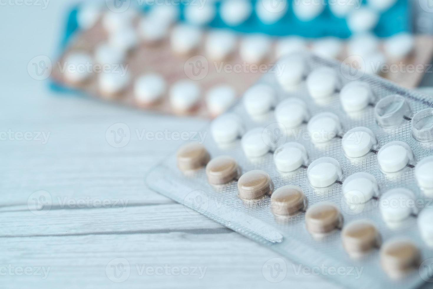 Birth control pills on neutral background, close up photo