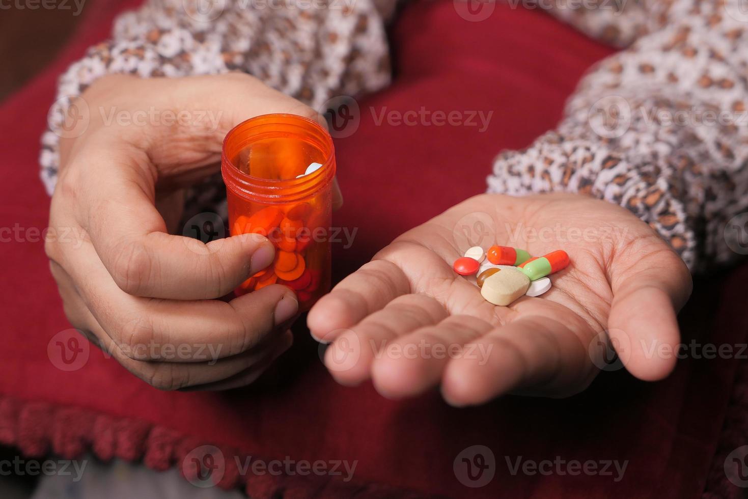 Cerca de la mano de la mujer tomando pastillas foto