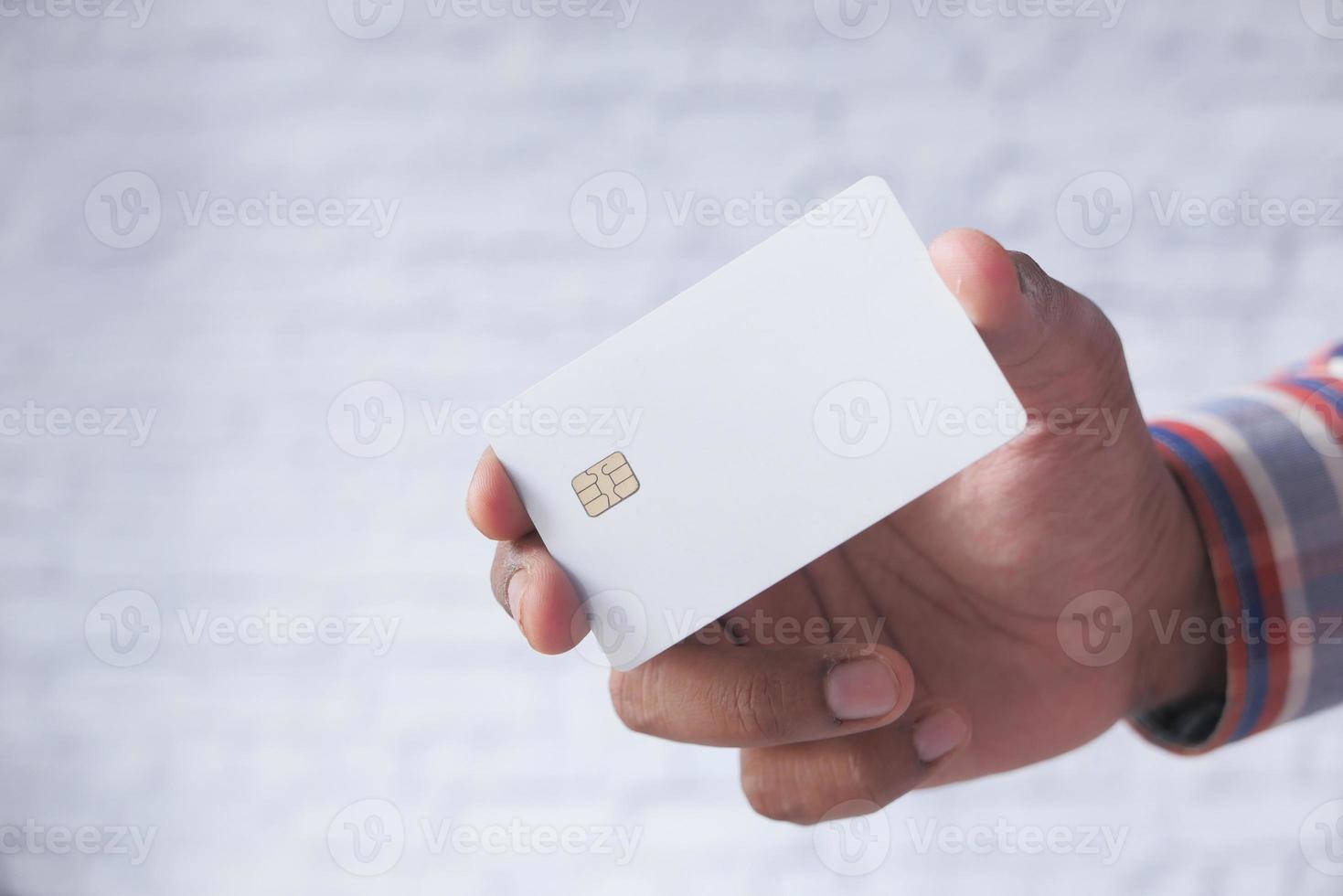 Hand holding white credit card photo