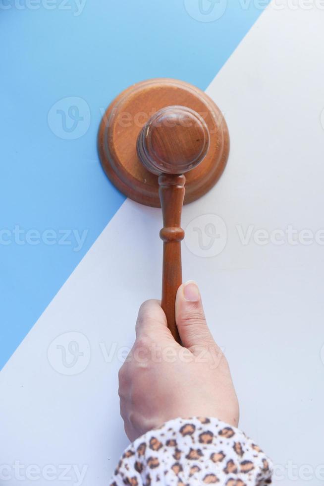 Top view of person's hand striking a gavel photo
