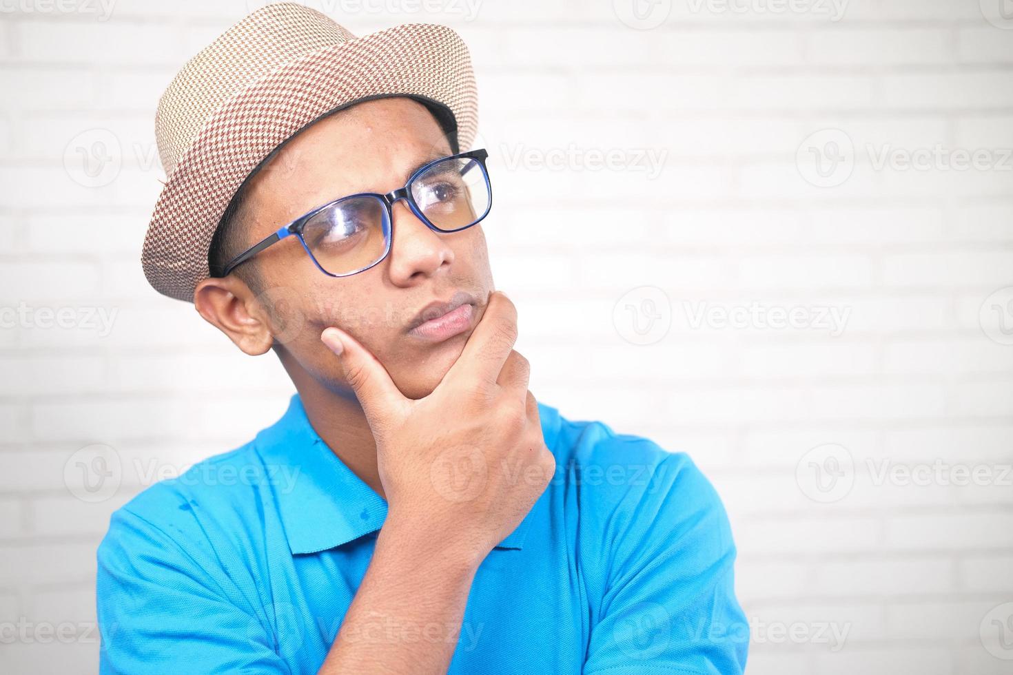 Thoughtful man with hat and eyeglass looking away photo