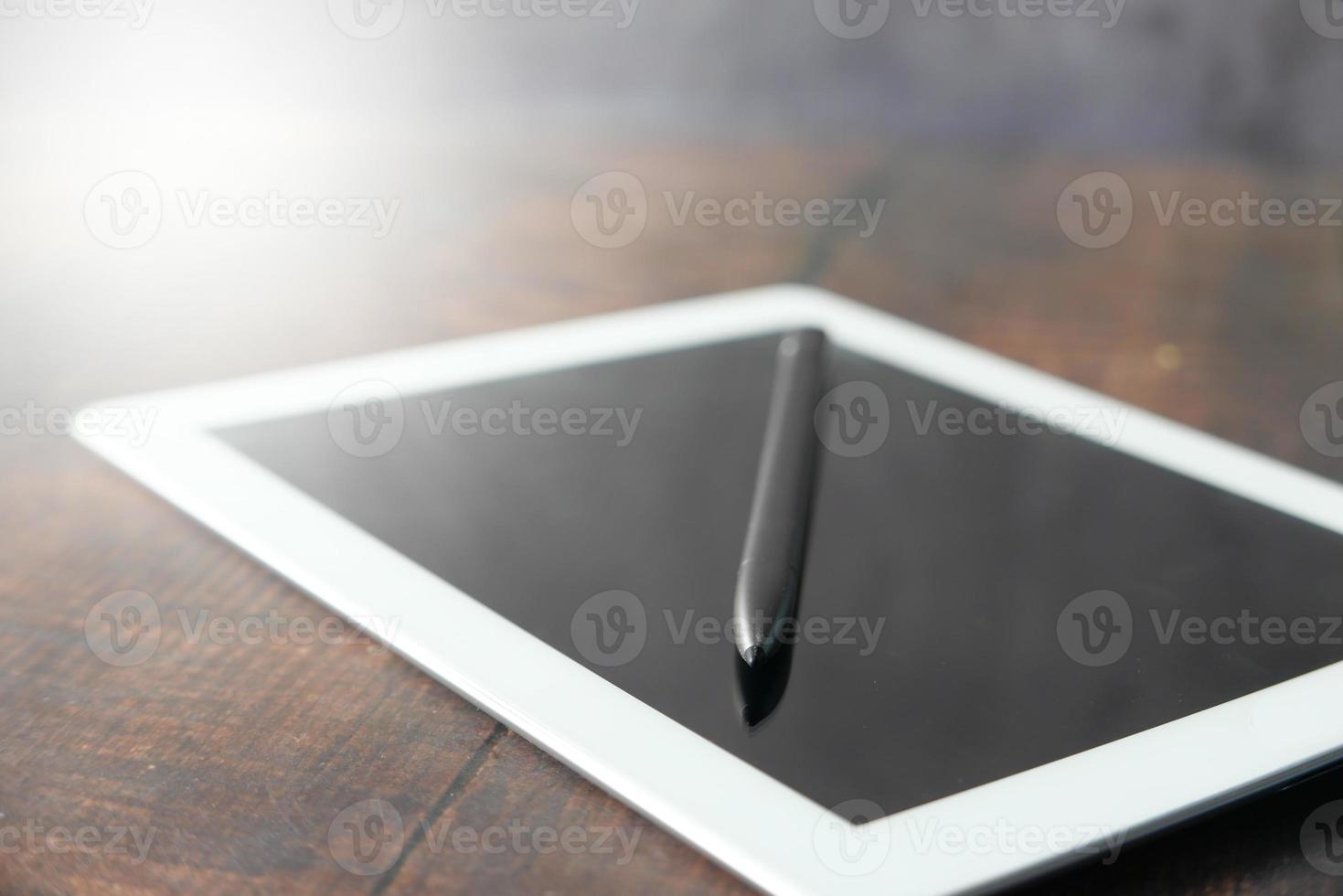 Digital tablet with graphics pen on table photo