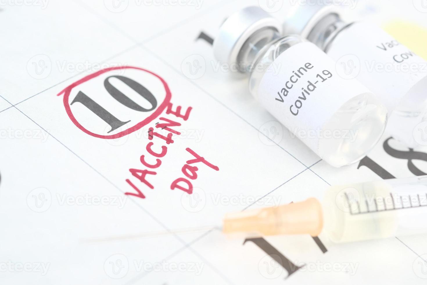 Vaccine and syringe on calendar photo